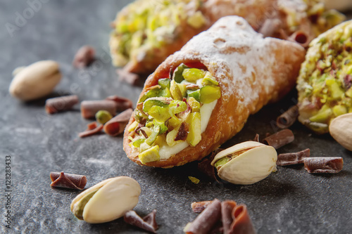 Sweet homemade cannoli stuffed with ricotta cheese cream and pis