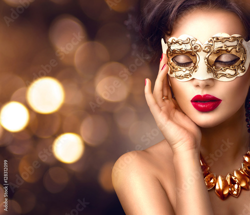 Beauty model woman wearing venetian masquerade carnival mask at party. Christmas and New Year celebration