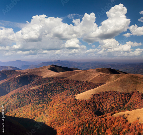 Beautiful landscape of mountains. View of autumn hills covered by trees and great clouds in distance.
