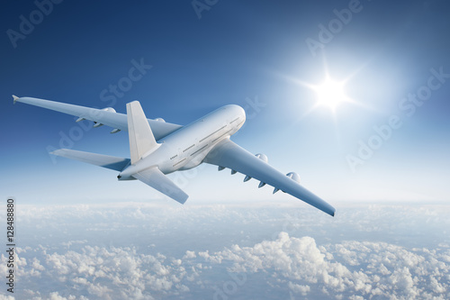 Big plane flying towards with the sun in blue sky