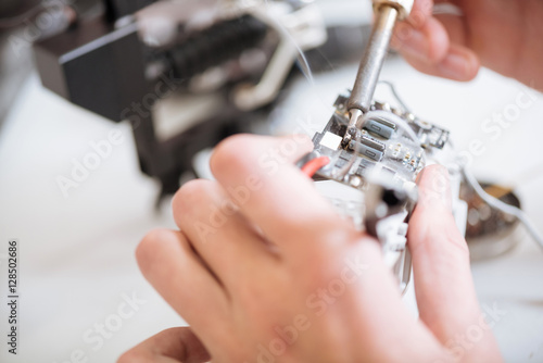 Close up of young mans hands using chip and soldering