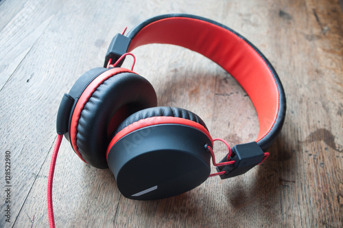 casque audio rouge et noir sur table en vieux bois