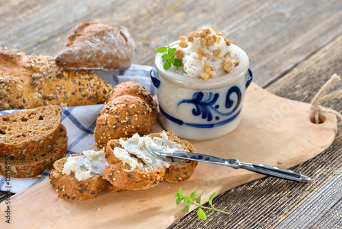 Deftiges Griebenschmalz im Schmalztopf mit rustikalem Brot serviert - Hearty lard with greaves and onions in a rustic stoneware pot served with fresh corn bread