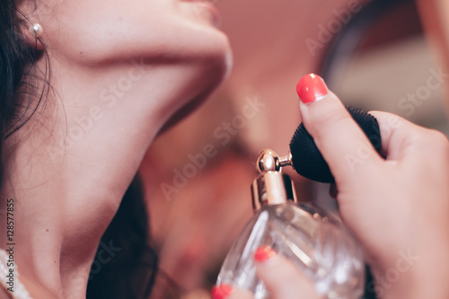 donna sensuale mette il profumo sul collo