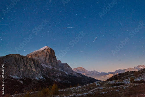 Mountain landscape in Dolomite. Night scene with stars and peak covered with snow. Italian Alps.
