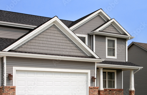 New home with vinyl siding, gutters, roof