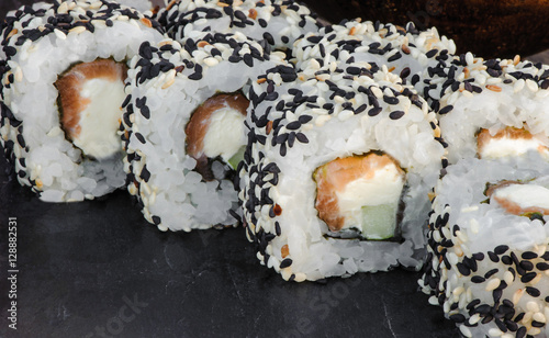 Japanese sushi roll philadelphia on black stone. Selective focus. Blurred foreground and background. Macro view