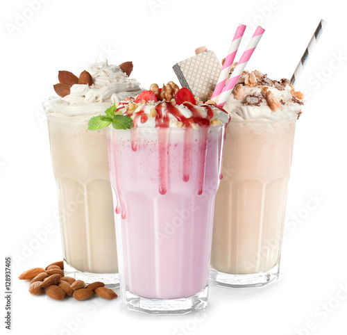 Glasses with delicious milk shakes on white background.