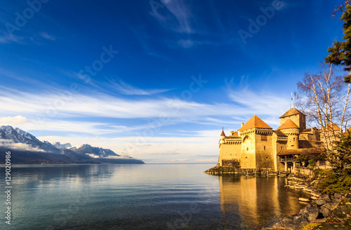 Castle on a lake front with blue sky and mountains