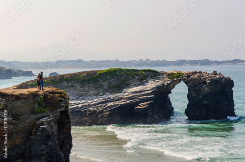 people gazing landscape near cliffs in beach of cathedrals
