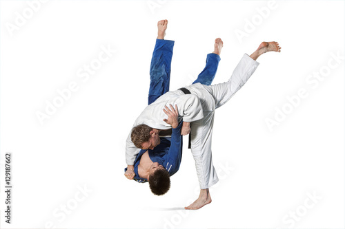 Two judokas fighters fighting men on white