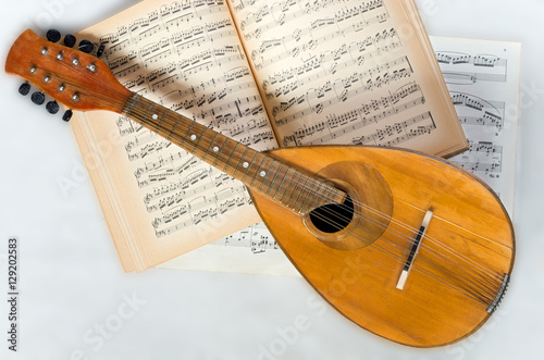 Old mandolin with music notes on a white background. Stringed musical instrument.