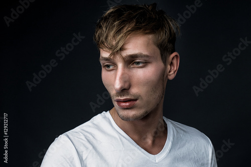 handsome young man in white t shirt posing in studio