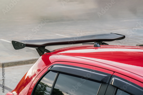 Car part ; Close up detail of a custom racing carbon fiber spoiler on the rear of a modern car with copy space 