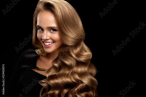 Beautiful Woman With Long Shiny Blonde Wavy Curly Hair. Beauty