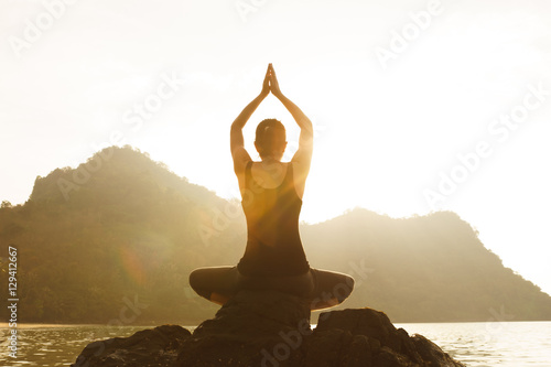 Young fit woman using yoga technique for meditation and well-bei