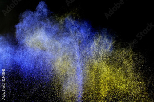 abstract of blue and yellow powder explosion on black background
