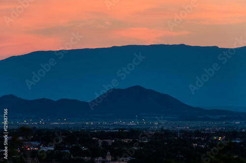 Aerial cityscape of Santa Fe, New Mexico with mountain during pink and blue sunset
