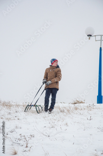 Happy teenager with sled