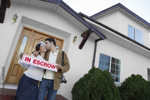 Portrait of a happy couple kissing outside new house