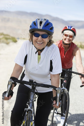 Portrait of senior female friends riding bicycle