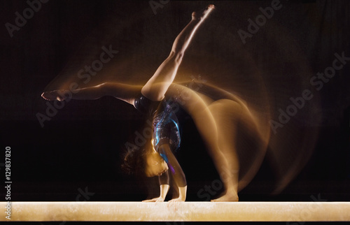 Multiple exposure image of female gymnast in motion on balance beam