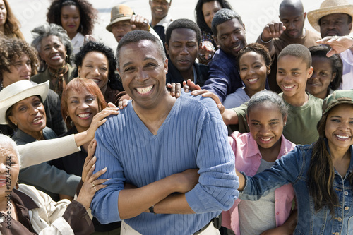 Portrait of cheerful mature man surrounded by people