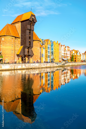 Morning view on the riverside of Motlawa river with beautiful buildings and famous historic gate of the old town in Gdansk, Poland