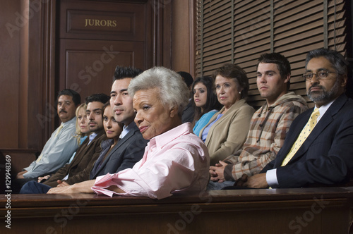 Zróżnicowana grupa jurorów siedzących w ławach przysięgłych sali sądowej