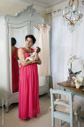 Drag queen wearing nightwear holding doll