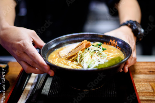 Cook geeting ready the Ramen for serving