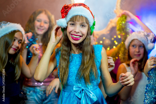 Group of cheerful young girls celebrating Christmas. Headphones