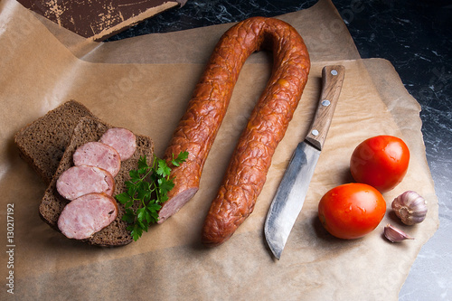 Slices of smoked sausage with spice, herbs and vegetables on the