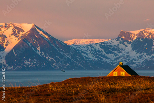 A house in front of snowy mountains