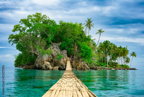 Bamboo hanging bridge over sea to tropical island