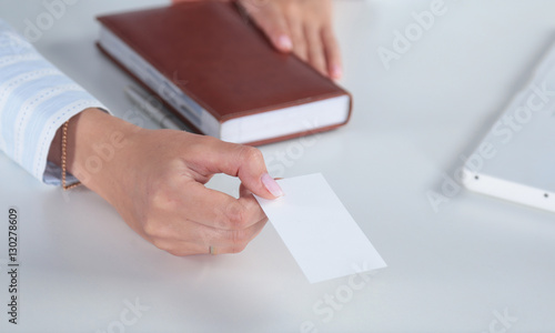 Smiling business woman handing a blank card over white background
