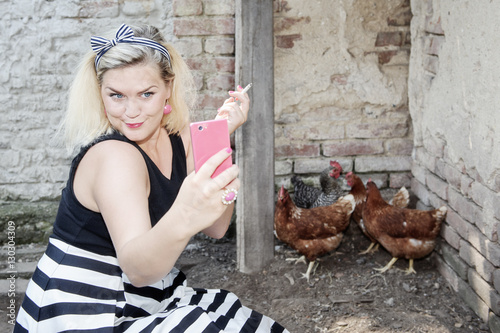 Housewife making selfie next to the flock of hens - Smartphone photography