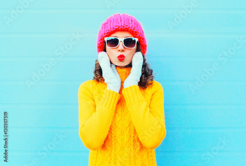 Fashion portrait woman blowing red lips makes air kiss wearing a