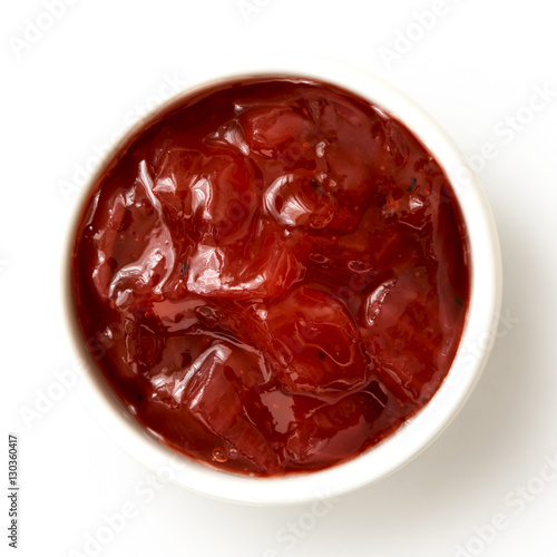 Red onion chutney in ceramic bowl isolated on white from above.