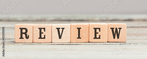 Word review written with wood cubes on table
