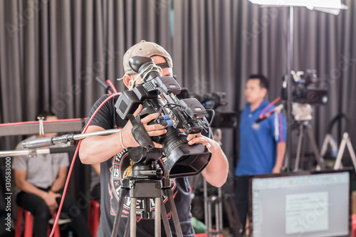 man use digital video camera with lens equipment in professional