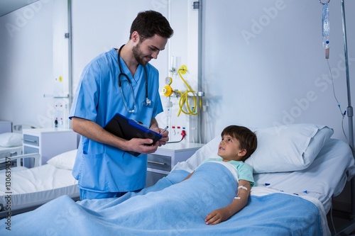 Male nurse interacting with patient during visit in ward