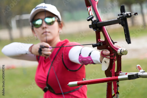 Female athlete practicing archery in stadium