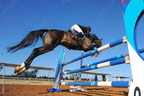 Rider on horse jumping over a hurdle during the equestrian event