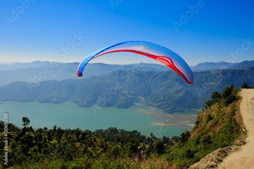 Pokhara, Nepal - November 3rd, 2016: View of a paraglider preparing to launch itself in the air.