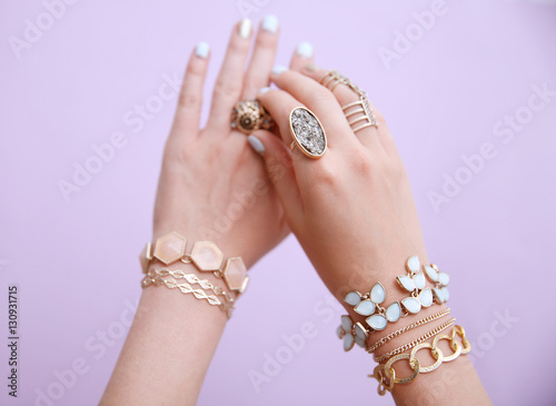 Female hands with jewelry on color background