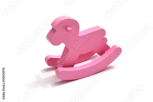 Różowy drewniany konik na biegunach. Pink wooden rocking horse.