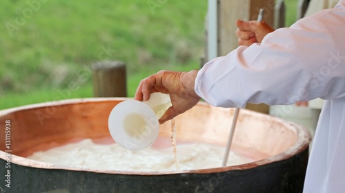 cheesemaker pour rennet into the great copper cauldron to make c