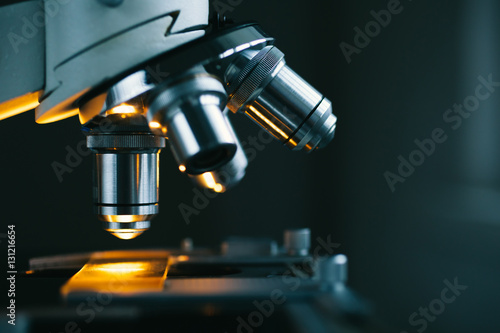 Close up of examining of test sample under the microscope in laboratory.