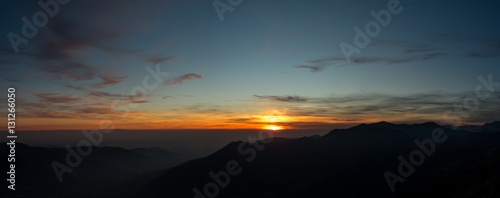 Fiery sunset from mountain pick with thin glazes in the sky evening. Fall season. Orobie alps. The summit of Mount Rena. Bergamo Italy. 